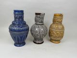 three vases sitting next to each other on a white surface