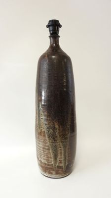 un vase marron avec un couvercle noir sur fond blanc