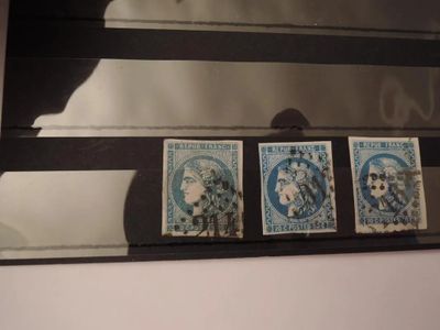 trois timbres posés sur une étagère devant un miroir