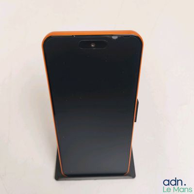 l'arrière d'un téléphone portable noir et orange posé sur un support