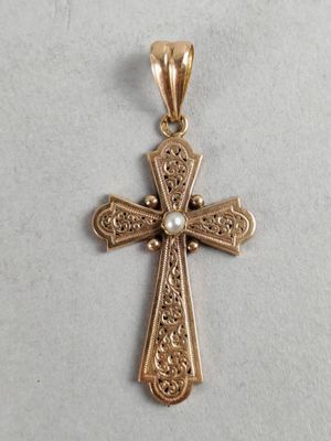a gold cross with a pearl in the center on a white background
