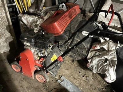 a red lawn mower that is sitting in a garage