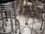four stools that are sitting on a tiled floor