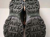 the soles of a pair of black hiking shoes on a white surface