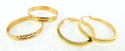 three pairs of gold hoop earrings on a white background