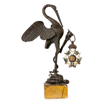 bronze statue of a crane holding a star and a bell