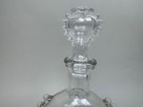 a glass decanter on a silver tray on a table