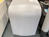 a white toaster sitting on the floor next to other appliances