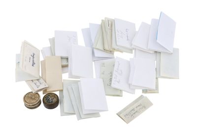 une pile de cartes et une pièce de monnaie posées sur une surface blanche