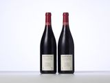 two bottles of red wine sitting on top of a table