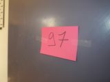 a pink post it on the door of a room
