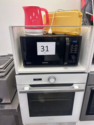 Dans une cuisine, plusieurs fours à micro-ondes sont empilés les uns sur les autres.