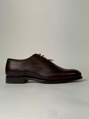 a close up of a pair of brown shoes on a white surface
