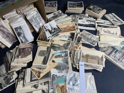 a pile of old photos on a table with a pair of scissors