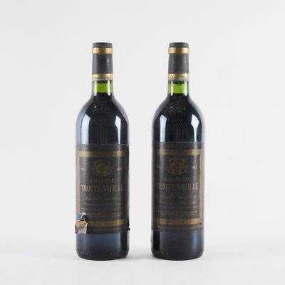 deux bouteilles de vin posées l'une à côté de l'autre sur une surface blanche