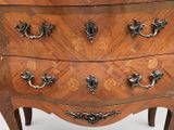 a wooden chest of drawers with ornate carvings on it