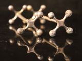 a close up of a pair of silver rings on a black surface
