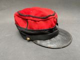 un chapeau rouge surmonté d'un ruban noir