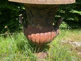 un vase en pierre posé au milieu de l'herbe