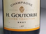 a bottle of champagne sitting on a table next to a bottle of wine