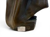 sculpture of a man ' s head on a book with a tag on it