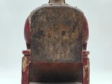 an old wooden chair with a man sitting on it