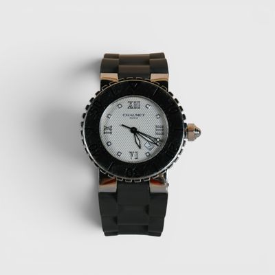 un gros plan d'une montre sur une surface blanche avec un fond blanc