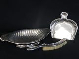 deux plats plaqués argent et une brosse sur fond noir