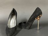 a pair of black sued heels with a leopard print heel
