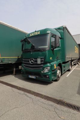 deux camions verts garés l'un à côté de l'autre sur un parking