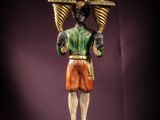 a statue of a man holding two baskets on his head