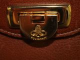 a close up of a brown purse with a gold clasp