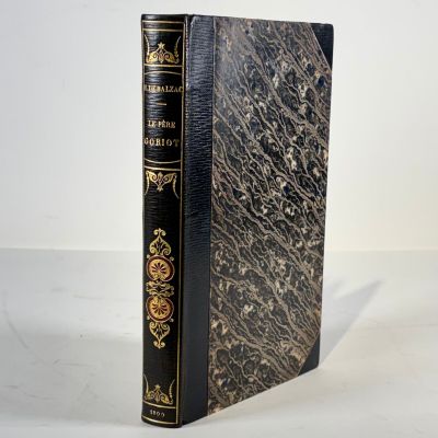 an old book sitting on top of a table next to a white wall
