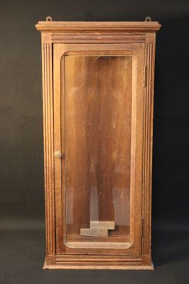 an old wooden clock with a glass case on a black background