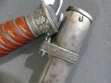 a close up of a metal object with a red handle