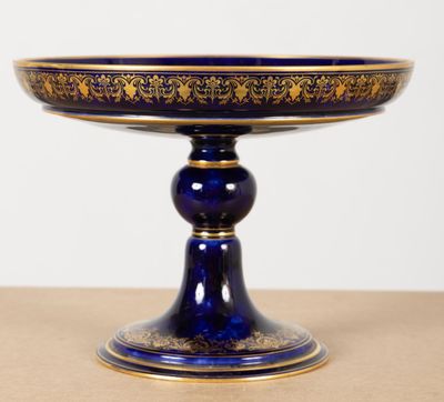an image of a blue and gold plate on a wooden table