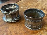 two silver cups sitting on a table next to each other
