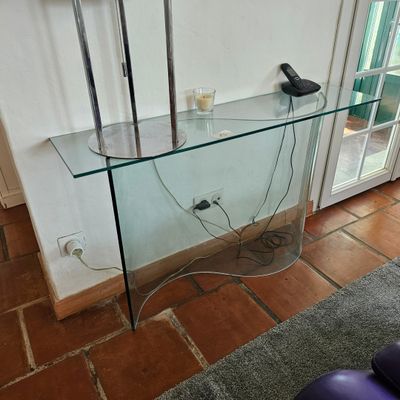 une table en verre sur laquelle est posé un téléphone, dans un salon