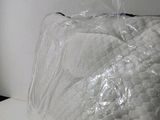 a large bag of plastic wrapped in plastic on a bed