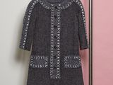 a black and white dress hanging on a hanger in front of a pink wall