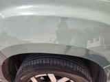 a cat that is sitting on the rim of a car