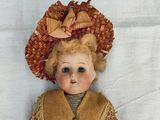 a doll that is sitting on a white surface