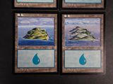 four cards with different designs on them on a black surface