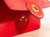 a red purse sitting on top of a wooden table
