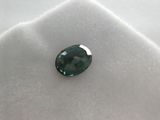 a close up of a green sapphire stone on a white cloth