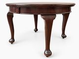 an oval table with two legs and a drawer on the top