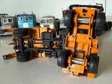Plusieurs camions miniatures sont alignés en rang sur une table