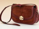brown sued cross body bag with a gold buckle