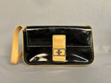 a black and yellow purse sitting on top of a white table