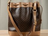 a brown and tan bucket bag sitting on top of a wooden table